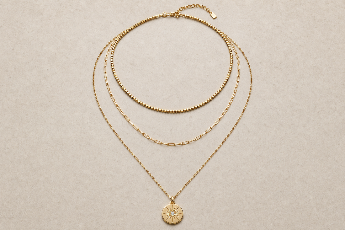 Three necklaces arranged in layers from short to long on a neutral surface