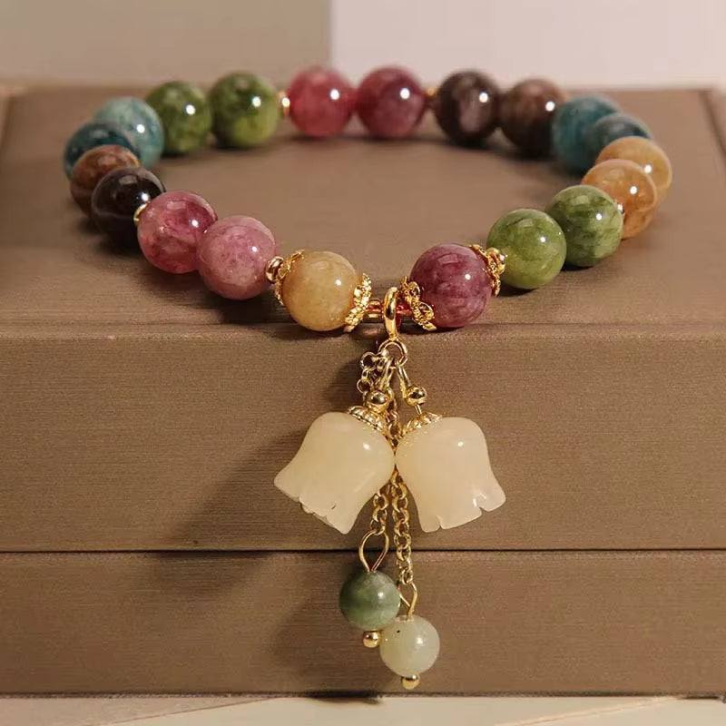 Colorful bracelets stacked on a wrist against a white background