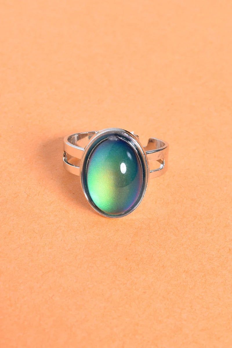 Close-up of Retro Aura Mood Ring with silver band and color-changing oval stone displaying 90s vintage style